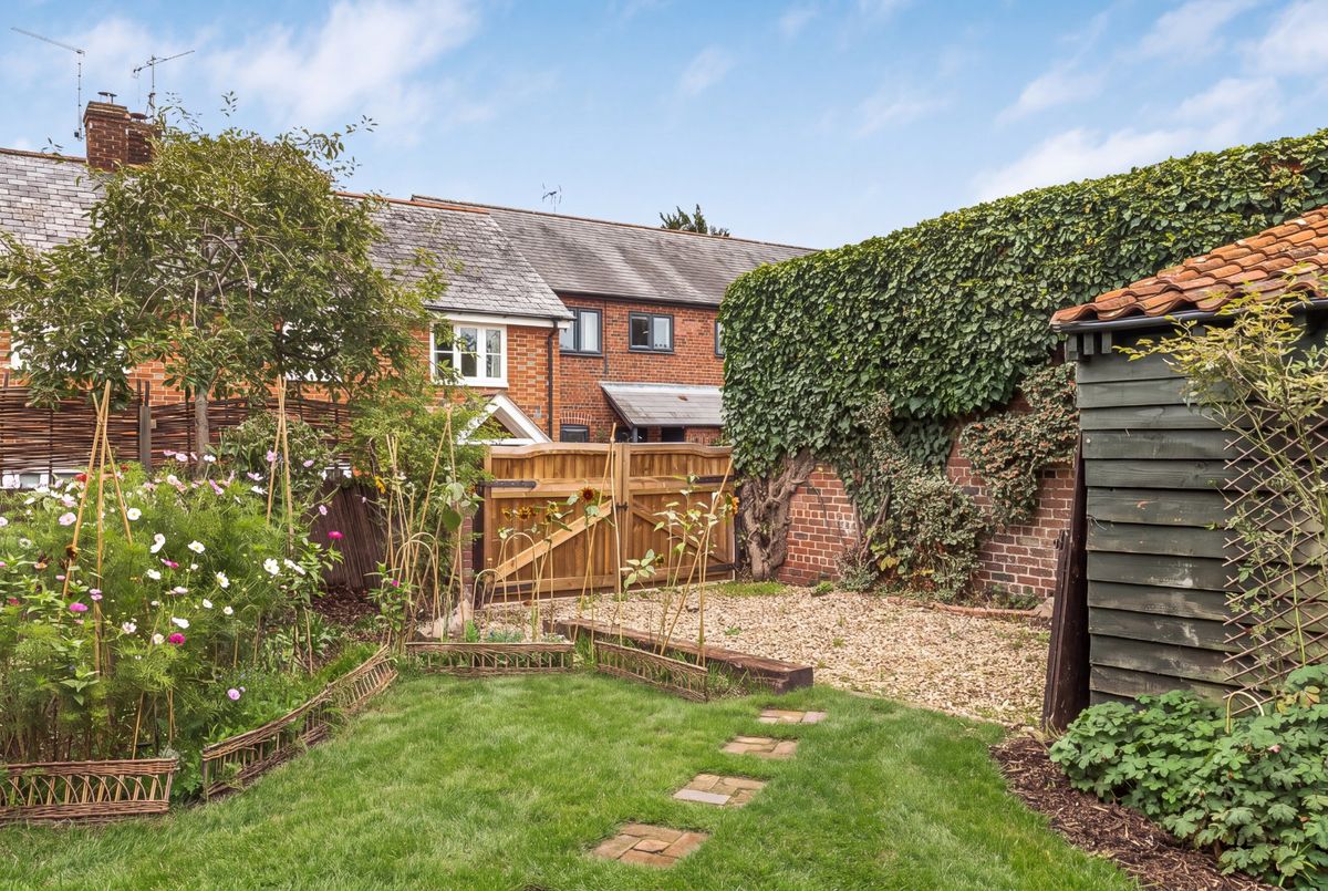 The gated gravel drive at the rear of the garden, with the timber carport