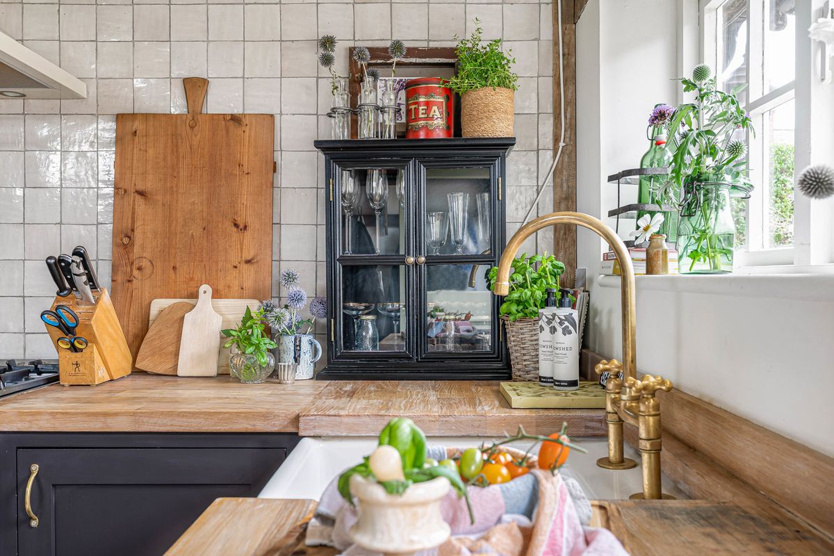 Timber worktop, chopping boards and a glazed cabinet beside the kitchen window