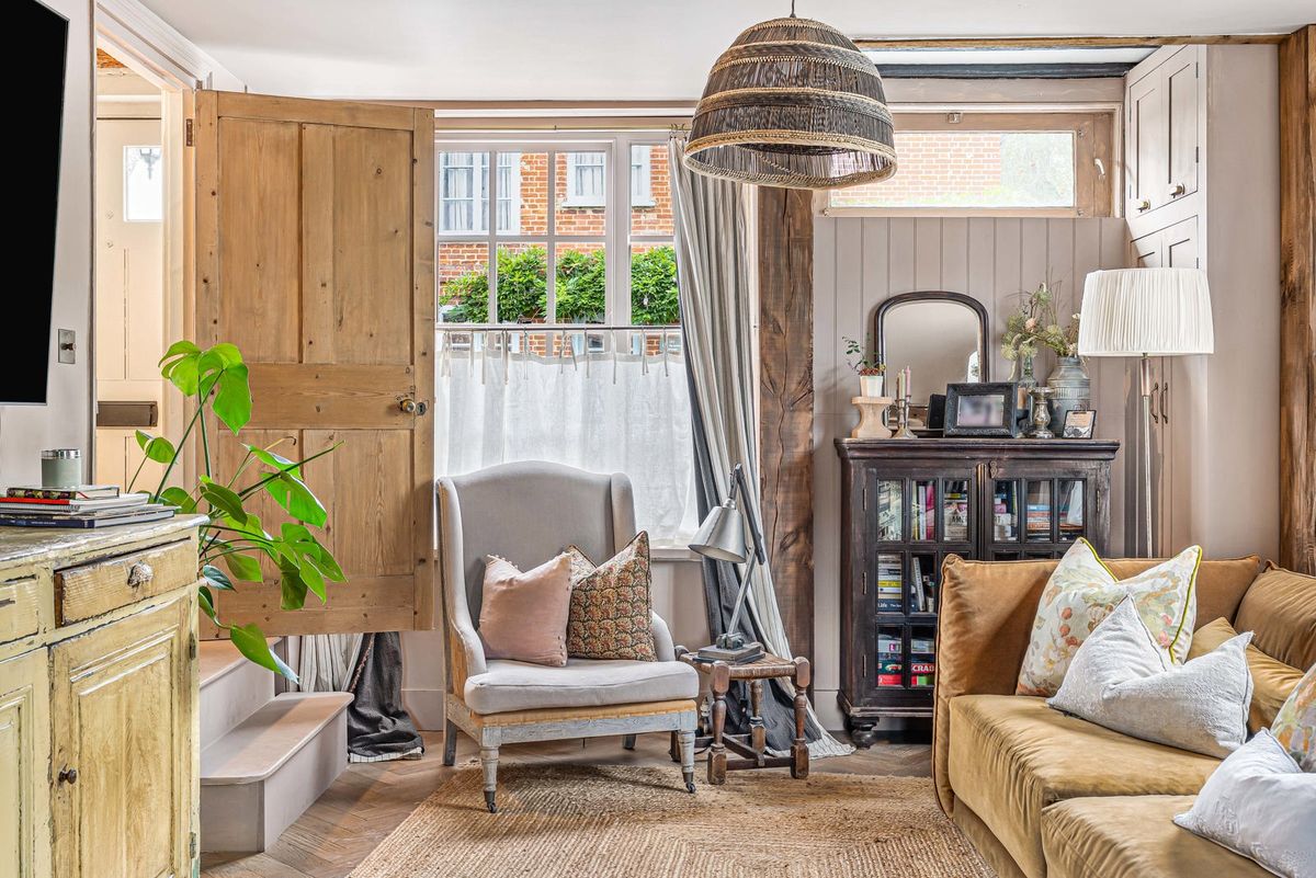 A reading chair beside a boarded door and a small window in the sitting room